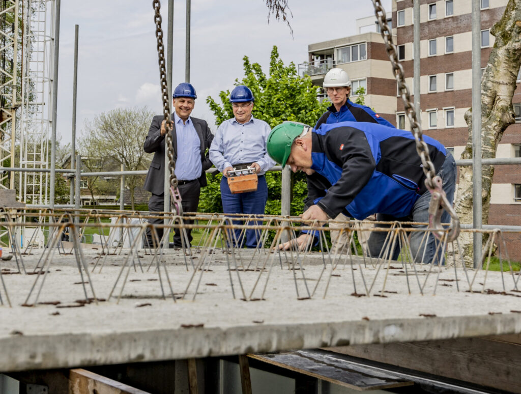 Wethouder Messerschmidt legt vloer nieuwbouw appartement sociale huurwoningen