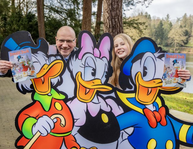 Donald Duck beleeft avontuur in Apeldoorn: eerste exemplaar feestelijk overhandigd in Berg & Bos