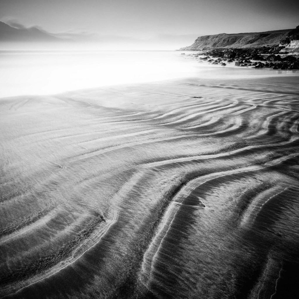 Zwart-wit foto van een kustlandschap met sporen in het zand gemaakt door Frank Hoogeboom
